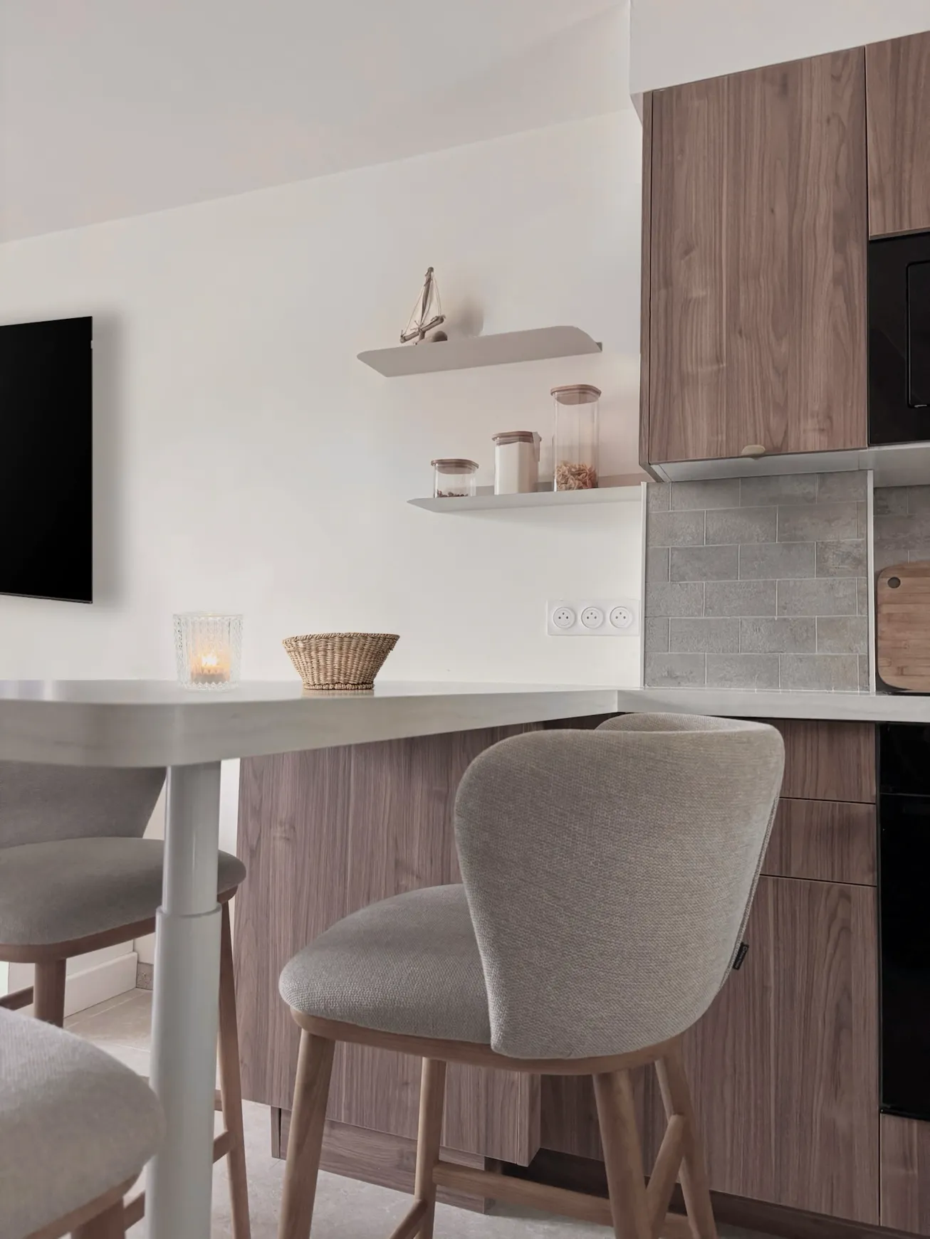 Coin repas optimisé avec mobilier aux courbes douces et étagères murales pour les petits espaces.